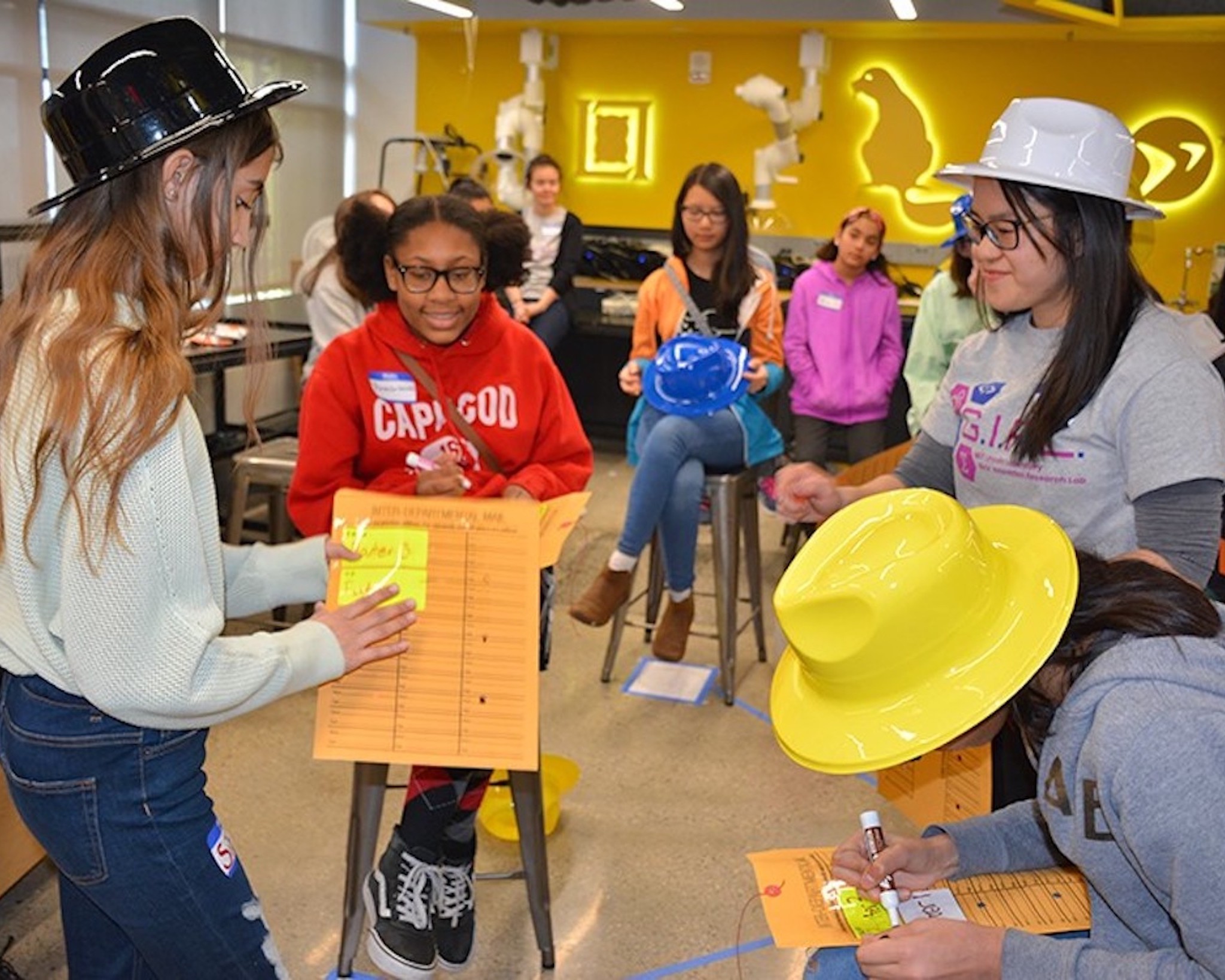 Middle school girls learning cryptography and code breaking during a team task.