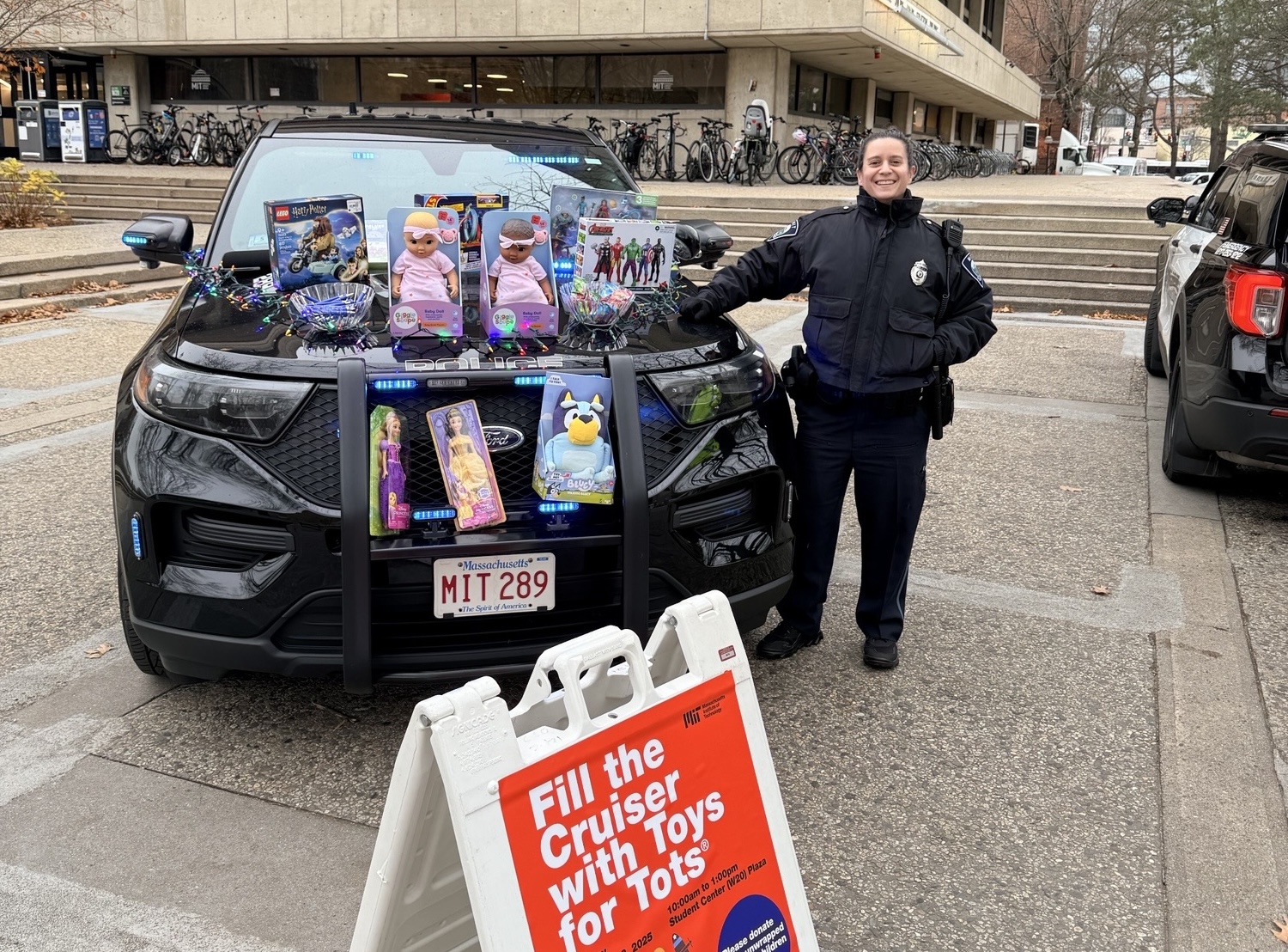 Officer Sue Fuller-DeAmato showing off donations at the Fill-The-Cruiser event supporting Toys for Tots