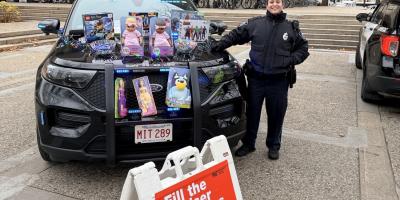 Officer Sue Fuller-DeAmato showing off donations at the Fill-The-Cruiser event supporting Toys for Tots