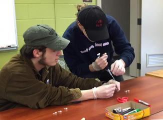 Student learning pipetting technique with a Biobits kit.