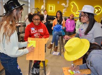 Middle school girls learning cryptography and code breaking during a team task.